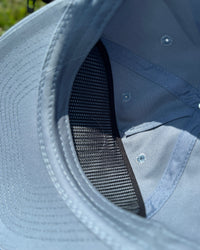 Close-up of a blue cap with mesh lining and visible stitching.